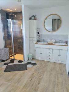 ein Bad mit einer Dusche, 2 Waschbecken und einem Spiegel in der Unterkunft Charmante maison Les Cèdres Bleus in Loon-Plage