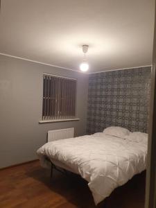 ein Schlafzimmer mit einem weißen Bett und einem Fenster in der Unterkunft Home near Rugby Station for contractors and Work Commuters, 5 bedroom, Free Parking & Garden 