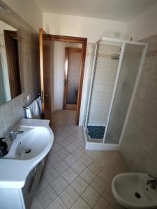 y baño con lavabo blanco y ducha. en Appartamento Mercantini, en Monsampolo del Tronto