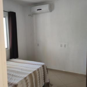 a white room with a bed and a air conditioner at Casa Germania in Canoa Quebrada