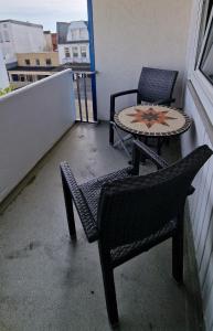 Duas cadeiras e uma mesa numa varanda em Haus Iderhoff Appartment 28 em Norderney