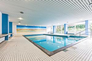 uma grande piscina num quarto com paredes azuis em Haus Iderhoff Appartment 28 em Norderney