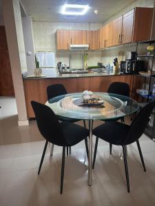a dining room table with chairs and a kitchen at Huge Entire apartment for Couples ,families & Groups -up to 5 Guests- with free pool, steam & Sauna ,JVC,Dubai in Dubai