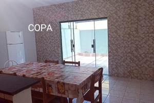 een eetkamer met een tafel en een glazen deur bij Casa para 12 pessoas perto da Basílica e da Feira in Aparecida