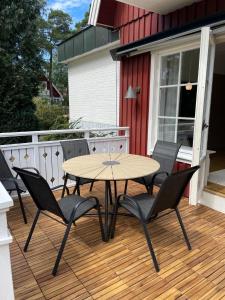 terraza de madera con mesa y sillas en el porche en Beach House Ängelholm, en Ängelholm
