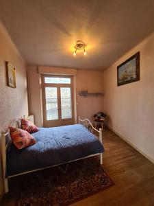 a bedroom with a bed with blue sheets and a window at Spacious Luxury 2 bed appartment in Carcassonne