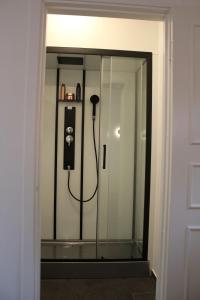 um quarto com um chuveiro e um telefone numa porta de vidro em Beach House Ängelholm em Ängelholm