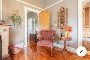 um quarto com uma cadeira, uma mesa e um espelho em The Guest Room em Abbeville