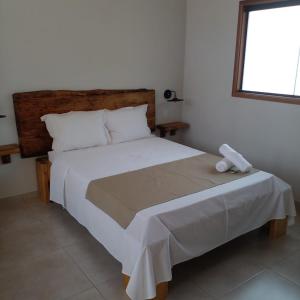 ein Schlafzimmer mit einem großen Bett mit weißer Bettwäsche und einem Fenster in der Unterkunft Chalé Vale Sereno Classic in Camanducaia