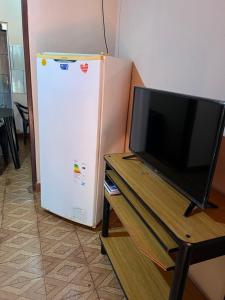 a television sitting on a table next to a refrigerator at Apart Belén in Puerto Iguazú