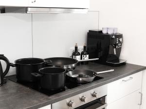 a kitchen with pots and pans on a stove at LIGHTPLACE • Design • Boxspring • Balkon • 2 Smart TV •Innenstadt in Braunschweig