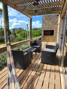 a wooden deck with chairs and a fireplace at MarEz in Punta Del Diablo