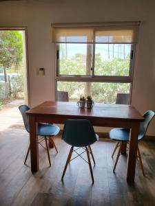a dining room table with chairs and a window at MarEz in Punta Del Diablo
