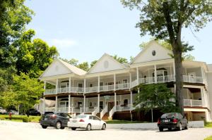 une grande maison blanche avec des voitures garées devant elle dans l'établissement Acorn Hill Lodge and Spa, à Lynchburg
