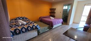 um quarto com 2 camas, uma mesa e uma janela em Habitaciones Tahiken em Olmué