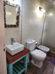 a bathroom with a sink and a toilet and a mirror at MarEz in Punta Del Diablo