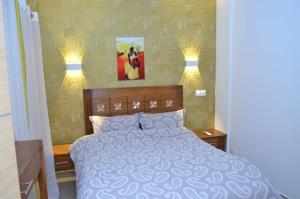 a bedroom with a bed with two lights on it at F3 Dakar Plateau Appartement Cité Emmergence in Dakar