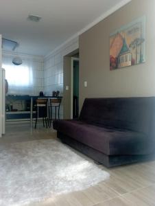 ein großes Sofa im Wohnzimmer mit Küche in der Unterkunft Aconchego Apartamentos da Serra in Canela