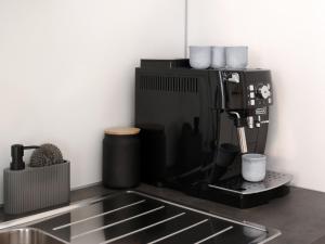 a coffee maker sitting on top of a kitchen counter at LIGHTPLACE • Design • Boxspring • Balkon • 2 Smart TV •Innenstadt in Braunschweig