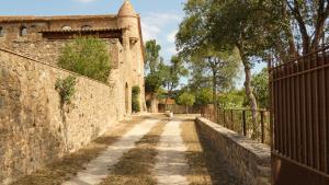 an alley in a castle with a fence at Mas Solés in Parlavà +26 photos