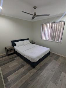 a bedroom with a bed and a ceiling fan at Huge Holiday Home 4Beds 2Baths in Gladstone near Shopping Center in Gladstone