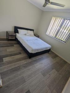 a bedroom with a bed and a window at Huge Holiday Home 4Beds 2Baths in Gladstone near Shopping Center in Gladstone