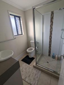 a bathroom with a toilet and a glass shower at Huge Holiday Home 4Beds 2Baths in Gladstone near Shopping Center in Gladstone