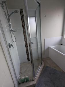 La salle de bains est pourvue d'une douche avec une porte en verre. dans l'établissement Huge Holiday Home 4Beds 2Baths in Gladstone near Shopping Center, à Gladstone