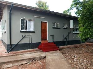 una casa con una puerta y escaleras delante de ella en Ramachi apartments, en Livingstone