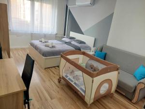 德布勒森的住宿－AwesHome City Apartment，小房间设有两张床和一张婴儿床