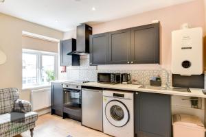 a kitchen with a washer and a dishwasher at 1 bed flat for two close to train station with private parking by Eagle Owl Property in Worthing