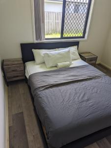 Christa's 4Bedroom Entire Private House Gladstone City في غلادستون: سرير كبير في غرفة مع نافذة
