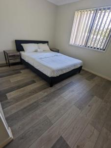 1 dormitorio con 1 cama y suelo de madera en Gladstone Entire House 4 Beds 2 Baths Air-conditioned in City, en Beecher