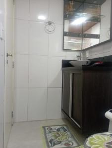 ein Badezimmer mit Waschbecken und Spiegel in der Unterkunft Aconchego Apartamentos da Serra in Canela + 12 Fotos