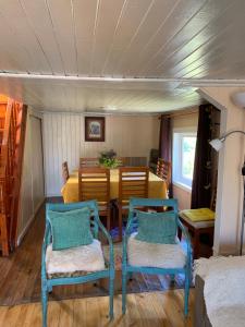巴拉斯港的住宿－Cabanas Klenner，一间设有两张蓝色椅子和一张桌子的用餐室