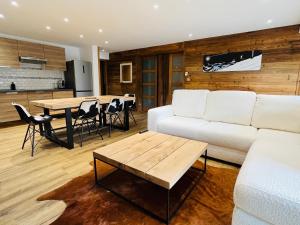 uma sala de estar com um sofá branco e uma mesa em Coup de coeur Montagnard - 2 chambres - Cheminée - Garage em Isola 2000