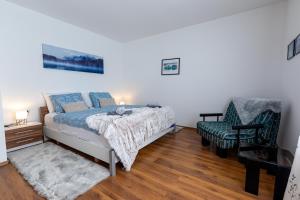 een slaapkamer met een bed en een stoel bij Apartmani Rumora Gorski kotar in Tuk Vojni