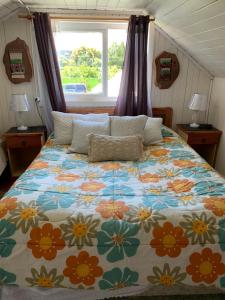 a bedroom with a large bed with a floral comforter at Cabanas Klenner in Puerto Varas