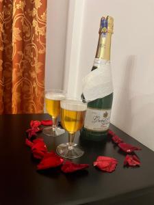 een fles champagne en twee glazen op een tafel bij HOSTAL DEL RIO in Gualaceo