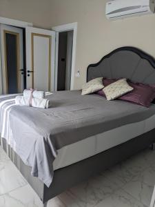 a large bed in a white room with pillows on it at Emerald Paradise Apartment in Avsallar