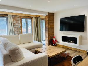 a living room with a couch and a fireplace at Coup de coeur Montagnard - 2 chambres - Cheminée - Garage in Isola 2000