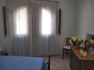 a bedroom with a window and a table with flowers at Casa Elena in Pula +3 photos