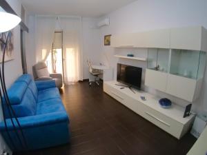 sala de estar con sofá azul y TV en The House of Grandma en Nápoles