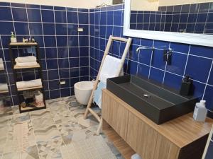 ターラントにあるle stanze di Eurialoの- 青いタイルのバスルーム(黒いシンク付)