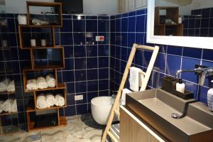 ターラントにあるle stanze di Eurialoの青いタイル張りのバスルーム(洗面台、トイレ付)