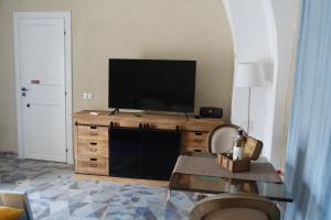 ターラントにあるle stanze di Eurialoのリビングルーム(木製ドレッサーの上にテレビ付)