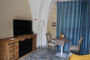 ターラントにあるle stanze di Eurialoのリビングルーム(テレビ、テーブル、椅子付)