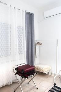 une valise rouge assise sur une chaise dans une pièce dans l'établissement Stylish Apartment Thessaloniki, à Thessalonique