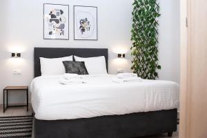 1 dormitorio con 1 cama grande con sábanas blancas en Stylish Apartment Thessaloniki, en Tesalónica