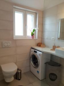ein Badezimmer mit einer Waschmaschine und einem Waschbecken in der Unterkunft Mila Holiday Home in Vodice